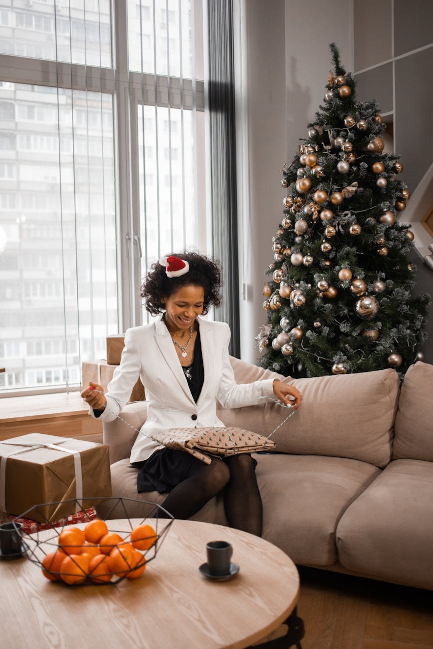a woman sitting on sofa opening a present