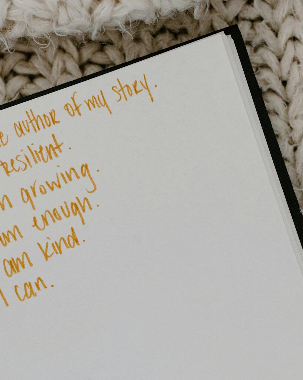a notebook with encouraging quotes on a knitted fabric