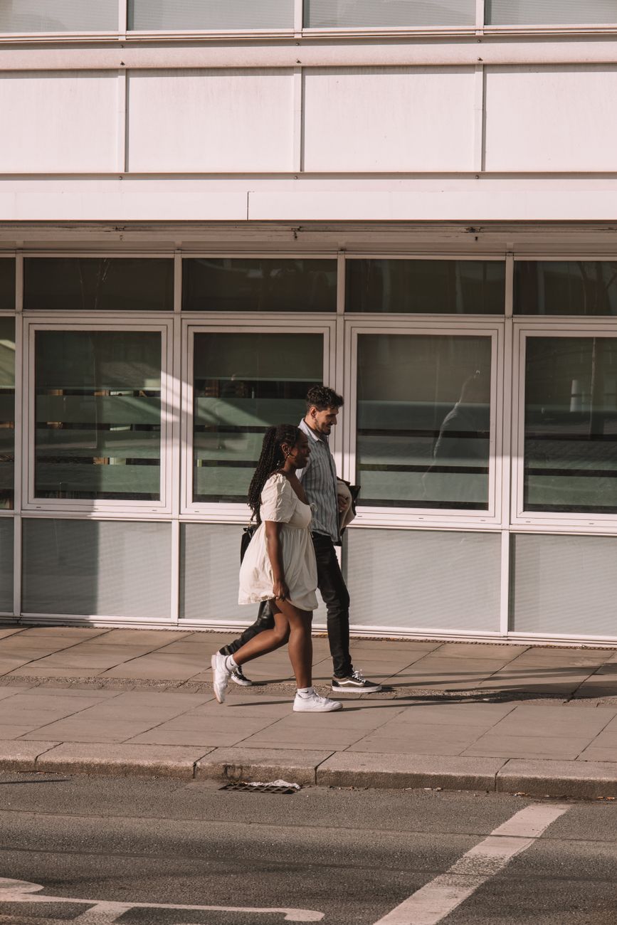 candid photo of a man and woman walking on a sidewalk
